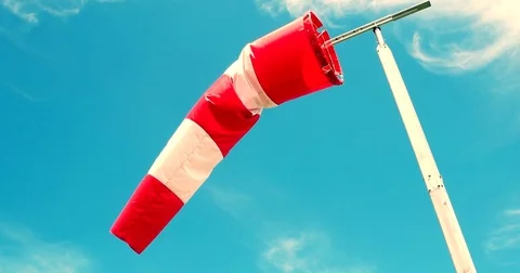 Windsock in moderate wind against blue sky with few clouds Stock Footage 74076635