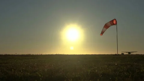 Windsock. Plane takes off. Red and white wind sock on wind. Sun shines into lens Stock Footage 204801310