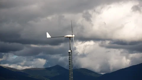 A windsock on a pole against the backdrop of mountains on a cloudy day. Stock Footage 253563944