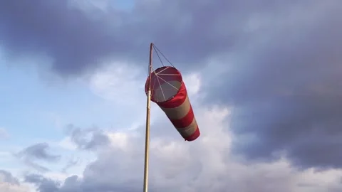 Windsock on pole under dramatic storm clouds, windy weather, aviation concept Stock Footage 320412671