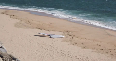 Windsurf board lying on sandy beach on sunny day Stock Footage 132228665