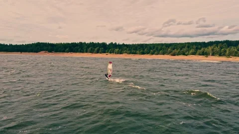 Windsurfer gliding across tranquil waters at sunset Stock Footage 307628912