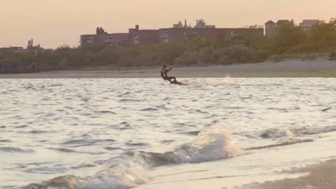 A windsurfer has the entire beach to himself as he enjoys the last hour Stock Footage 243172178