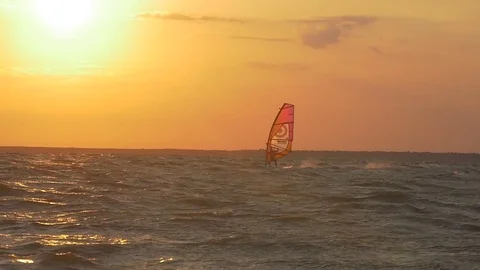 Windsurfer jumping against the setting sun Stock Footage 83707293