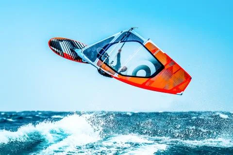 Windsurfer jumping in the waves during a summer day Stock Photos