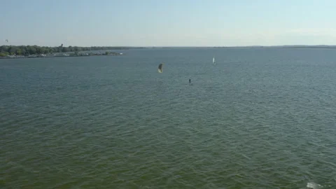 A windsurfer with a parachute floats on a board Stock Footage 207763865