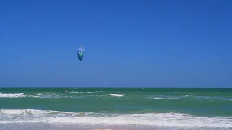 A windsurfer rides the waves on the beach in Hua hin. water sports on the sea Stock Footage 129182963