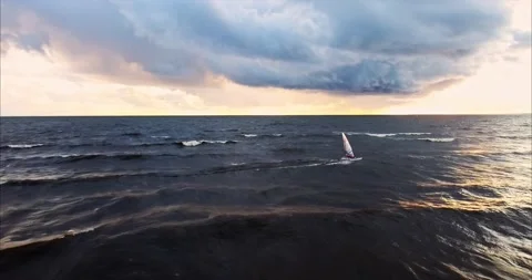 Windsurfer rides the waves during a storm at the setting sun Stock Footage 170567736
