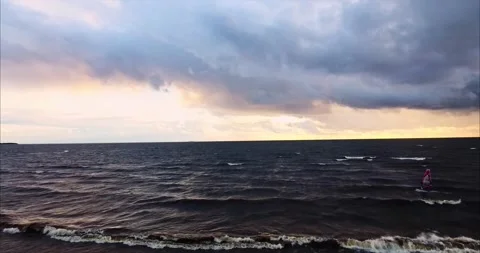 Windsurfer rides the waves during a storm at the setting sun Stock Footage 170567758