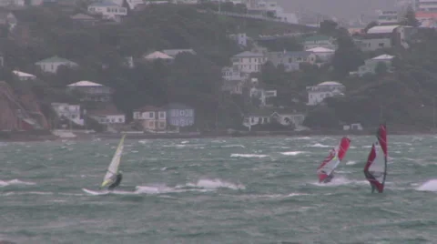 Windsurfer riding waves across a bay Video stock 1035971