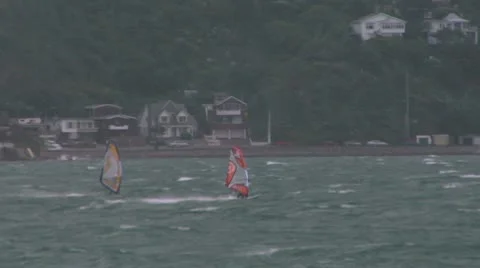Windsurfer riding waves across a bay Video stock 8984090