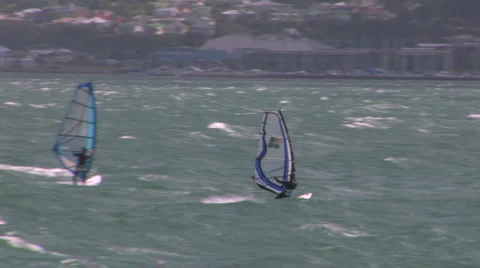 Windsurfer sailing across a bay Video stock 1035097