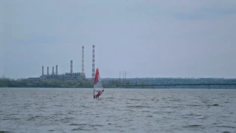 Windsurfer Sails along the Waves of the River in Cloudy Weather against the Stock Footage 159004845