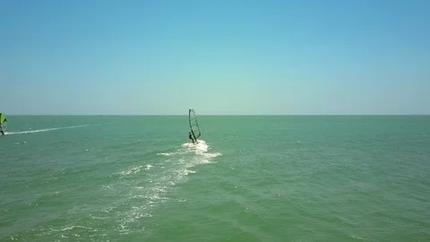 Windsurfer sails on ocean to horizon under blue sky Video stock 92126880