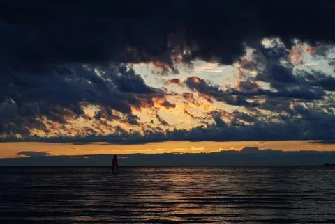 Windsurfer in the sea at sunset Stock Photos