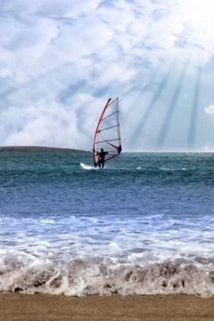 Windsurfer in a storm with rays of sunshine Stock Photos