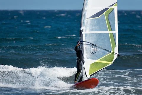 Windsurfer surfing the wind on waves in ocean sea Stock Photos