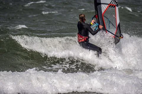 Windsurfer surfs through a wave. Close up. Stock Photos