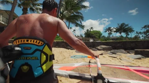 Windsurfer walks up the beach with windsurf board in Spreckelsville Maui Hawaii. Stock Footage 136265754