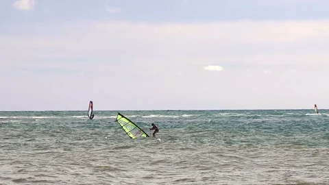 Windsurfer in the Waves  who Restarts after Pulling up the Sail of his Board Stock Footage 138933189