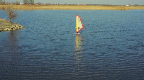 Windsurfer with white sail sails on lake fly over aerial shot Stock Footage 47526810
