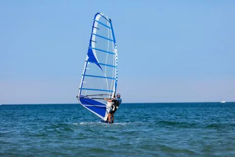 Windsurfer with windsurf on sea waves Stock Photos
