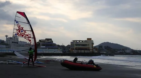Windsurfers on sand beach at sunset Stock Footage 59148708