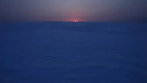 Windswept Patterns on the Snowfield and the Rising Sun from the Horizon Stock Footage 324960837