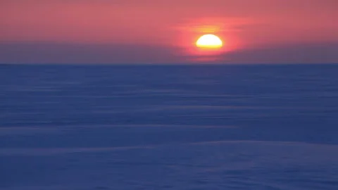 Windswept Patterns on the Snowfield and the Rising Sun from the Horizon Stock Footage 324960888
