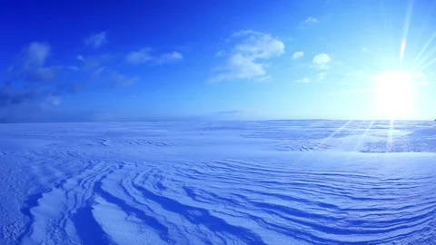 Windswept Patterns on the Snowfield, Flowing Clouds, and the Rays of the Morning Stock Footage 324960975