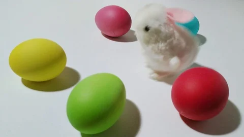 Windup mechanical bunny hops between easter eggs 1 Stock Footage 104922947