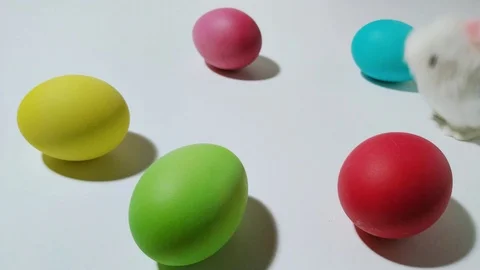 Windup mechanical bunny hops between easter eggs 3 Stock Footage 104923209