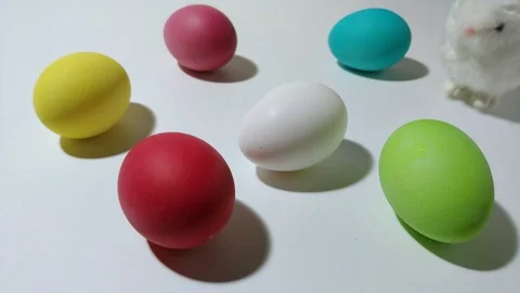 Windup mechanical bunny hops between easter eggs 4 Stock Footage 104923306