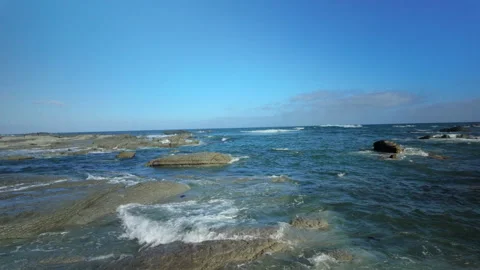 Windy coastal reef with waves rolling over shallow rocks Stock Footage 325696554