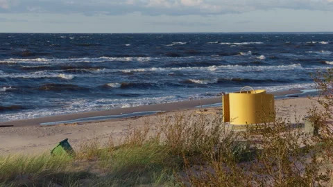 Windy coastline with rough sea waves, sandy shore, dunes and yellow beach bin Stock Footage 346558482