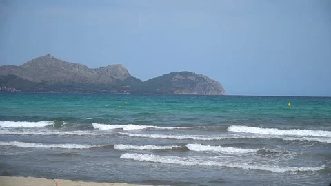 Windy day at the beach with mountains in the background Stock Footage 128350226
