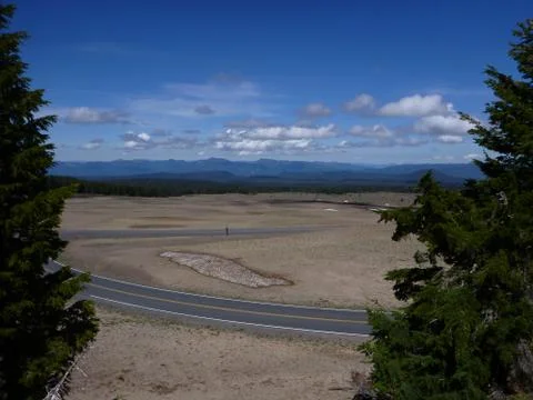 Windy road with clouds and trees and desert Stock Photos