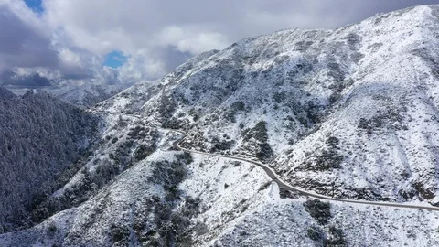 Windy road through snow covered mountain range Stock Footage 120629226