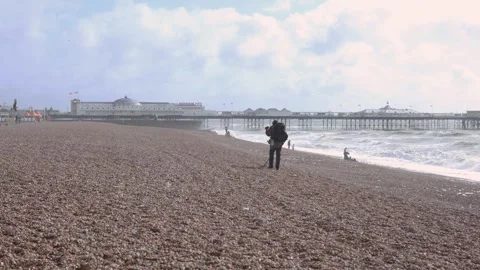 Windy seafront, Man with Metal Detector Walking on Pebble Beach Video stock 287444552