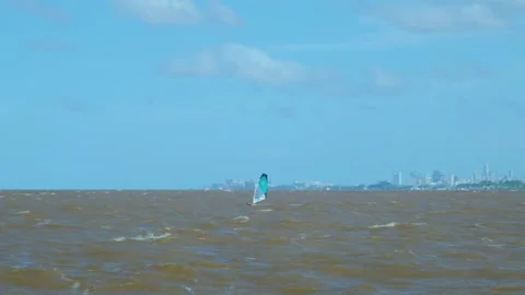 Windy weather, guy on a Sailboard sailing on the brown waves of the Luhan River Stock Footage 261124054