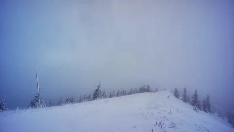 Windy winter mountain ridge covered with fresh snow in foggy cold weather and Stock-Footage 319842305