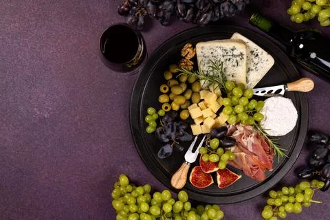 Wine and cheese board with grapes and appetizers Stock Photos