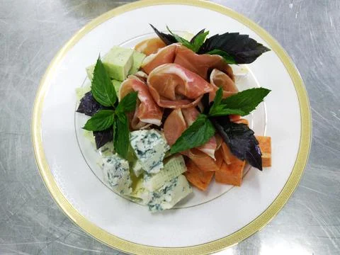Wine appetizer with different types of noble cheese and prosciutto Stock Photos