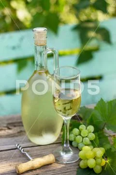 Wine background, wine concept. White wine bottles on wooden table. Stock Photos
