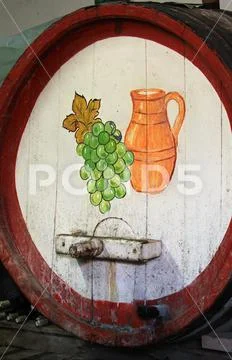 Wine barrel in winery with grapes & jug in cellar Stock Photos