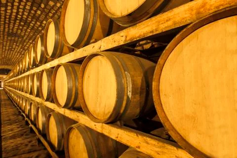 Wine barrels stacked in the cellar Stock Photos