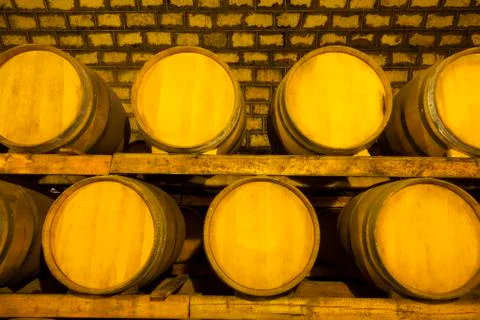 Wine barrels stacked in the cellar Stock Photos