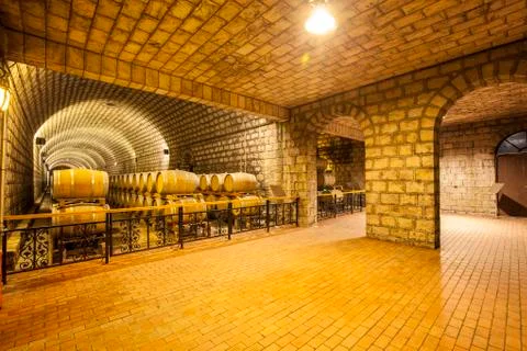 Wine barrels stacked in the cellar Stock Photos