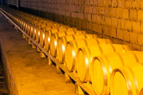 Wine barrels stacked in the cellar Stock Photos