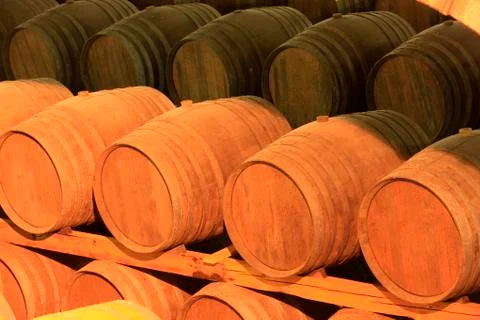 Wine barrels stacked in the cellar Stock Photos